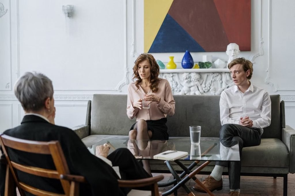 A couple discussing relationship difficulties with a therapist during couples therapy in Belgium.